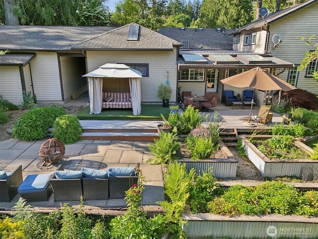 26821 NE 124th St, Duvall, WA 98019 - rear view of house featuring a garden, a shingled roof, a wooden deck, a patio, and an outdoor living space with a fire pit