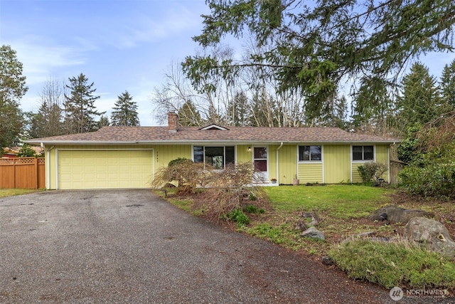 single story home featuring fence, aphalt driveway, a front yard, a chimney, and a garage