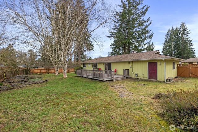 back of house featuring a yard, a fenced backyard, and a wooden deck