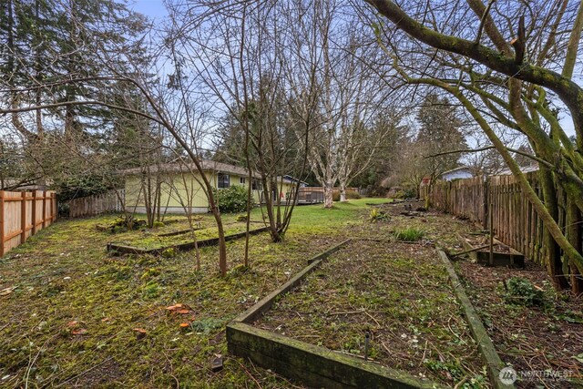 view of yard with a vegetable garden and a fenced backyard