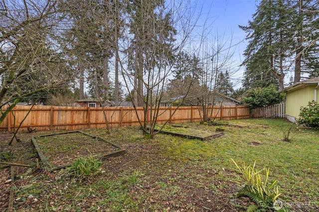 view of yard with a garden and a fenced backyard