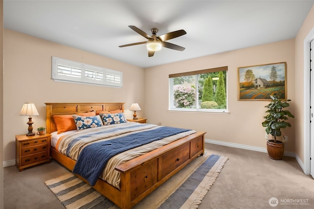 bedroom featuring baseboards, light colored carpet, and ceiling fan