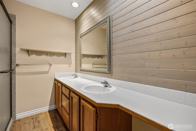 bathroom featuring double vanity, recessed lighting, wood finished floors, and a sink