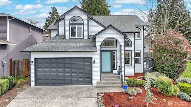 view of front of house with a garage, fence, concrete driveway, and a shingled roof