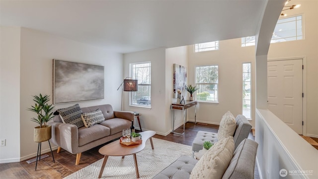 living area with wood finished floors, visible vents, and baseboards