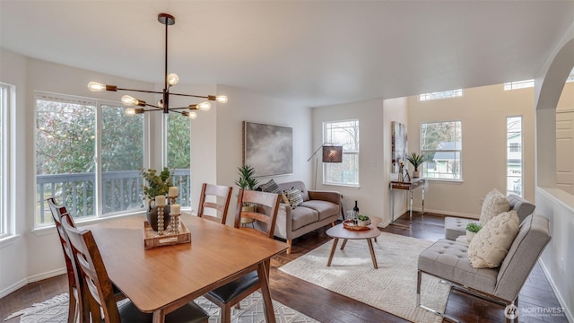 dining area with an inviting chandelier, wood finished floors, and baseboards