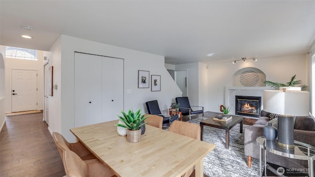 dining space featuring a premium fireplace, recessed lighting, and hardwood / wood-style floors