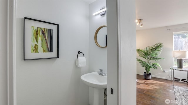 bathroom with wood finished floors, baseboards, and a sink