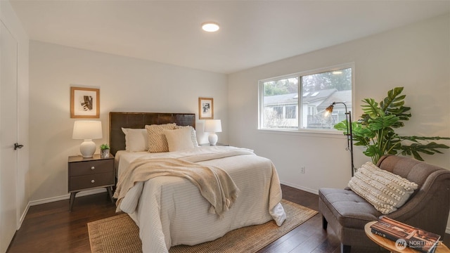 bedroom with dark wood-type flooring and baseboards