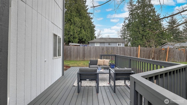 wooden deck with an outdoor living space and a fenced backyard