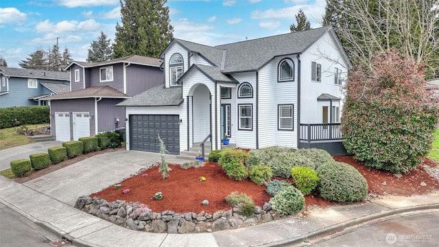 view of front of house featuring a garage, driveway, and a shingled roof