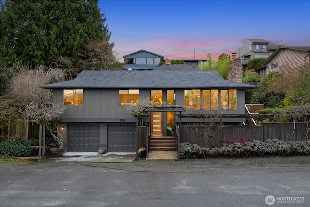 view of front facade with a garage, driveway, and a chimney