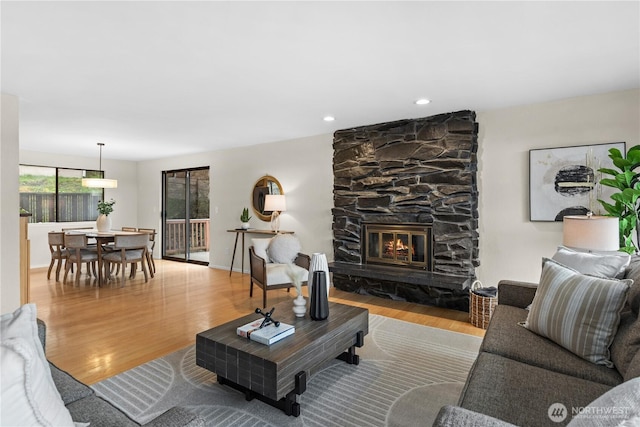 living room featuring recessed lighting, baseboards, wood finished floors, and a fireplace