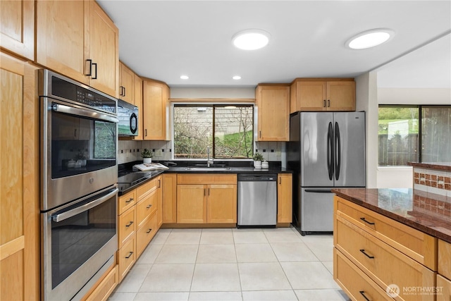 kitchen with decorative backsplash, black appliances, light tile patterned flooring, and a healthy amount of sunlight