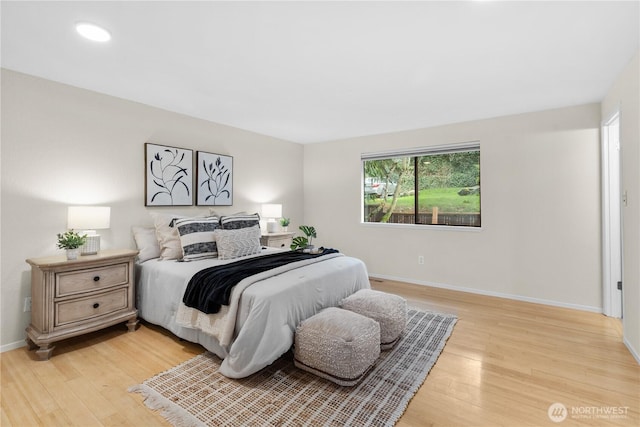 bedroom with light wood finished floors and baseboards