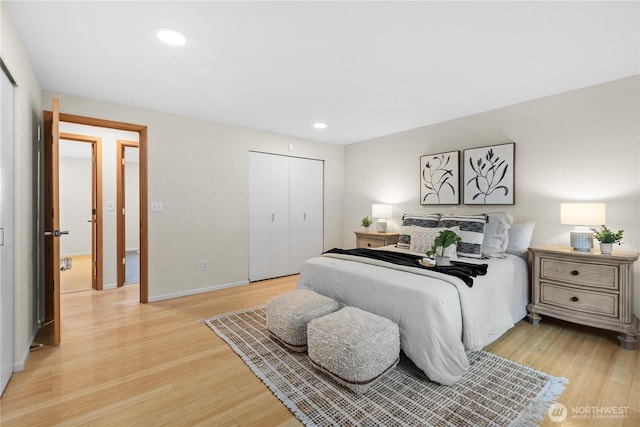 bedroom with recessed lighting, light wood-type flooring, baseboards, and a closet