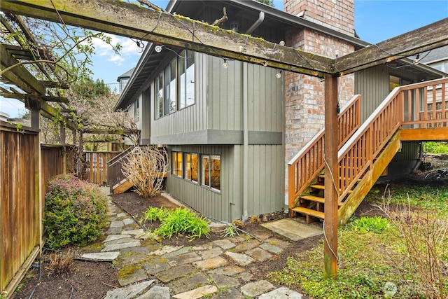 rear view of property featuring a chimney, fence private yard, and stairs