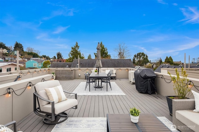 wooden terrace featuring outdoor dining space and a grill