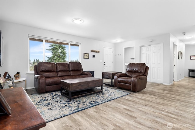 living area featuring baseboards and wood finished floors