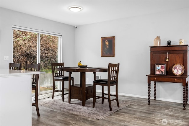 dining area featuring baseboards and wood finished floors