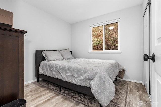 bedroom featuring wood finished floors, a closet, and baseboards