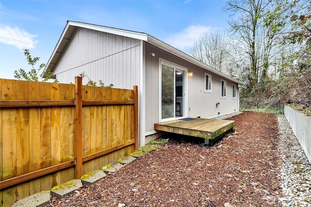 view of property exterior featuring a deck and fence