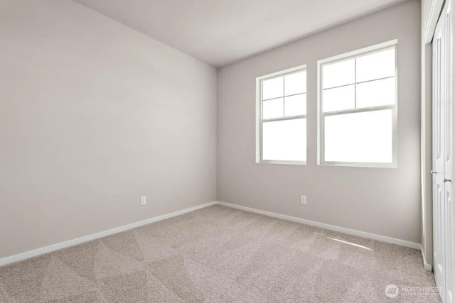 unfurnished room with carpet flooring and baseboards