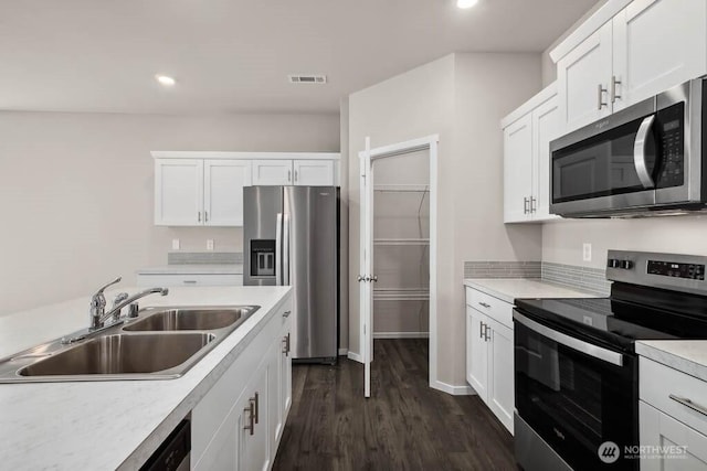 kitchen with visible vents, dark wood finished floors, light countertops, appliances with stainless steel finishes, and a sink