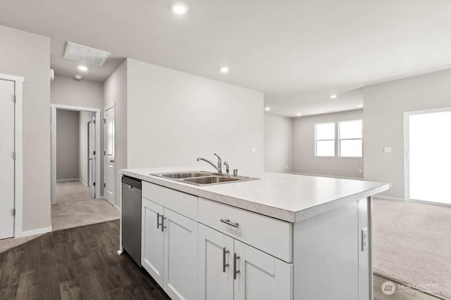 kitchen featuring an island with sink, a sink, white cabinets, light countertops, and dishwasher