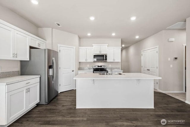 kitchen with visible vents, a sink, stainless steel appliances, light countertops, and white cabinetry