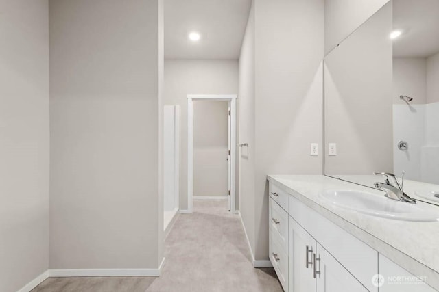 bathroom with a shower, baseboards, and vanity