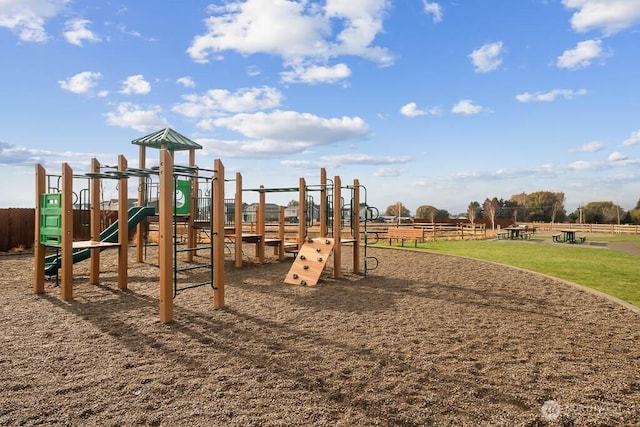 community jungle gym with fence and a lawn