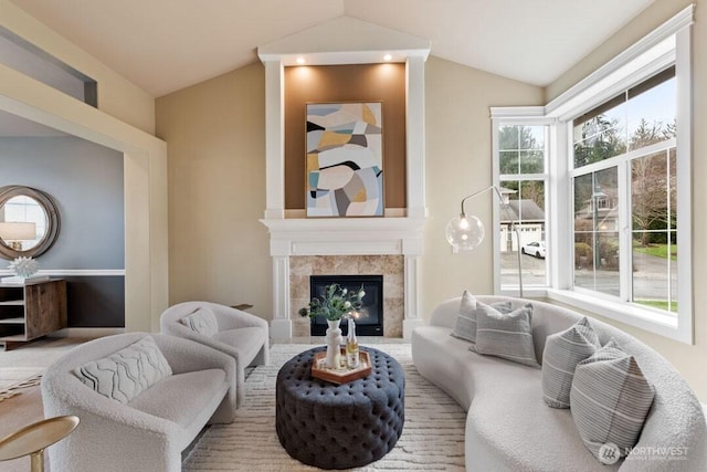 living room with lofted ceiling and a tile fireplace