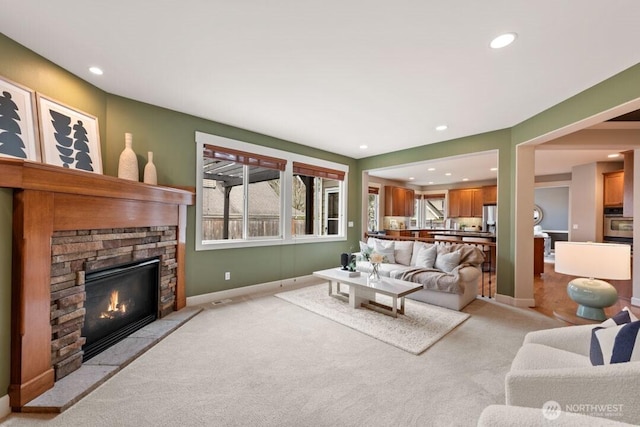 living room with light carpet, plenty of natural light, and a fireplace