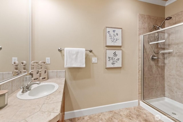 bathroom with tile patterned flooring, a stall shower, vanity, and baseboards