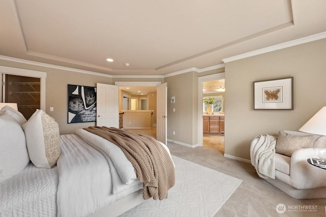 bedroom featuring a walk in closet, light carpet, a raised ceiling, crown molding, and baseboards