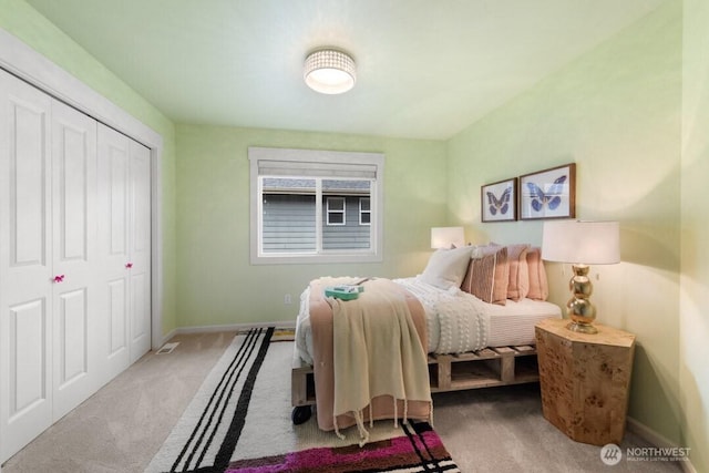 carpeted bedroom featuring a closet and baseboards