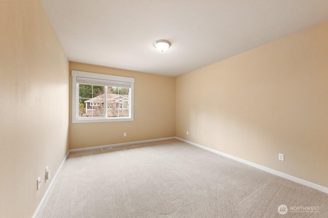 spare room with baseboards and carpet