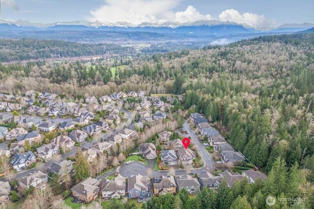 aerial view featuring a mountain view, a forest view, and a residential view