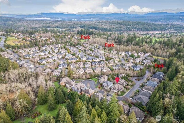 bird's eye view featuring a mountain view, a view of trees, and a residential view