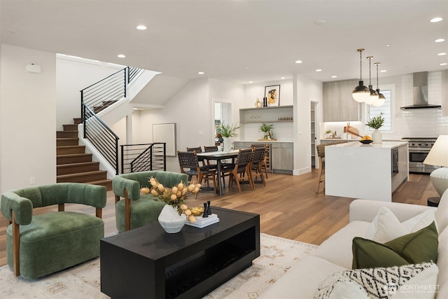 living area with stairs, recessed lighting, and light wood finished floors