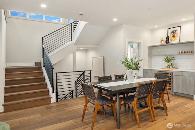 dining space featuring beverage cooler, recessed lighting, a healthy amount of sunlight, and light wood-type flooring