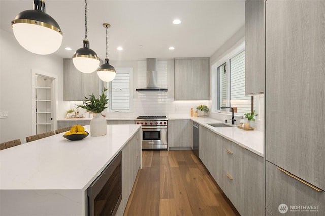 kitchen with a sink, wall chimney exhaust hood, modern cabinets, and stainless steel appliances