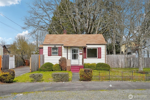 bungalow featuring fence