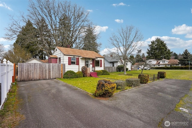 view of front of house featuring a gate, a front lawn, and fence