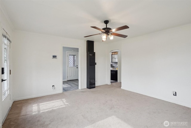 unfurnished room with carpet flooring, a ceiling fan, and ornamental molding