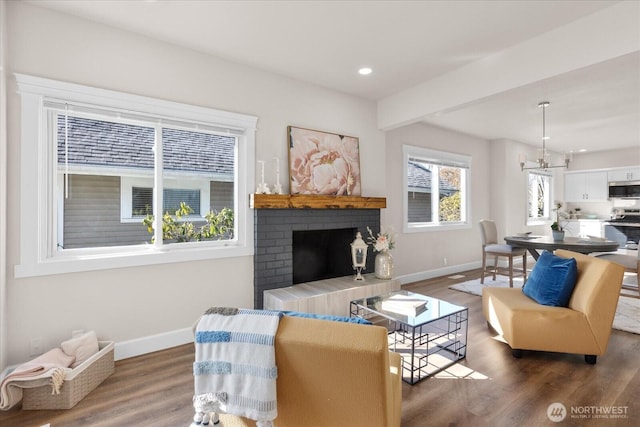 living room featuring recessed lighting, a fireplace, baseboards, and wood finished floors