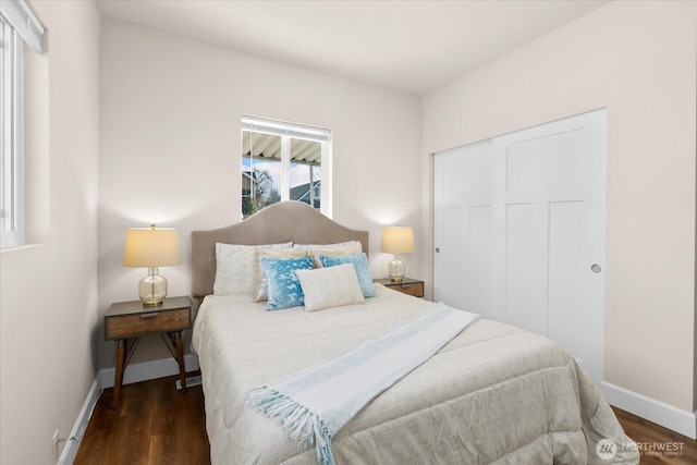 bedroom with a closet, baseboards, and wood finished floors