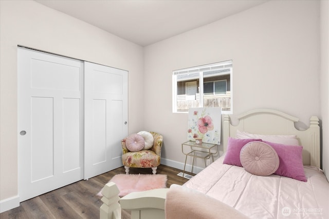 bedroom featuring visible vents, wood finished floors, baseboards, and a closet