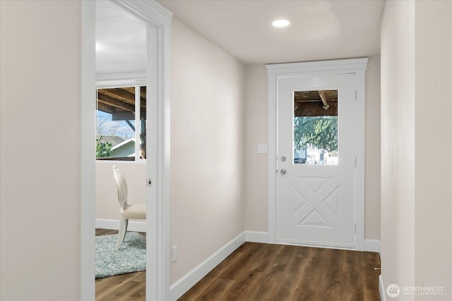 doorway with dark wood-type flooring and baseboards